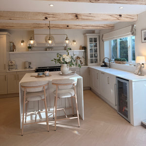 Modern kitchen with white cabinets, a dining area, and decorative elements.