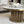 A modern round coffee table with a white marble top and a fluted gold metal base, styled in a contemporary living room setting.