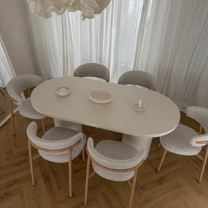 Dining room with a white oval table and matching chairs on a wooden floor.