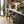 Modern kitchen with wooden shelves, bar stools, and a window view.