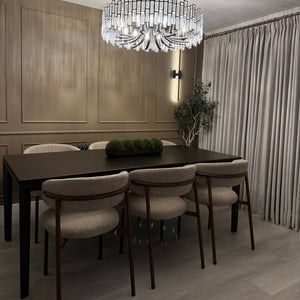 Dining area with a modern chandelier, table, and chairs in a well-lit room.