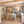 Modern kitchen with wooden beams and a woman at the counter.